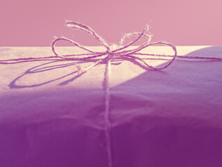 The gift is wrapped in brown paper and tied with twine.