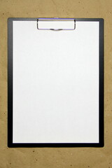 A tablet with a white sheet of A4 format on a beige craft paper.