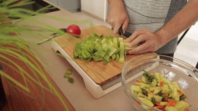 Cutting up some greens for a healthy salad meal - chopping lettuce, close up