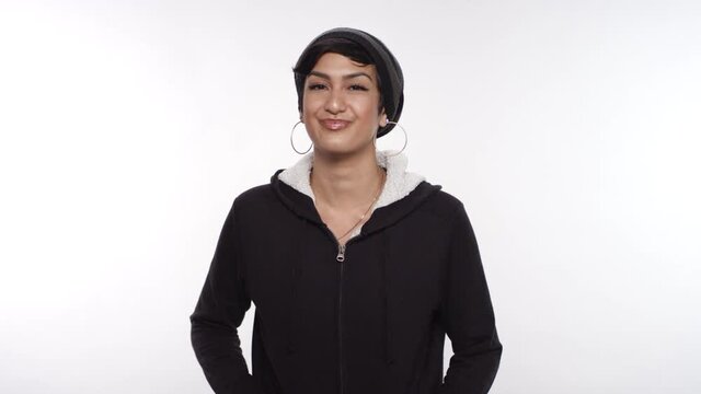 Portrait of a beautiful young woman of Middle Eastern descent smiling and nodding on a white studio backdrop