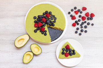 Tasty homemade avocado and lime Raw Cake with blueberries and raspberries, healthy vegan recipes