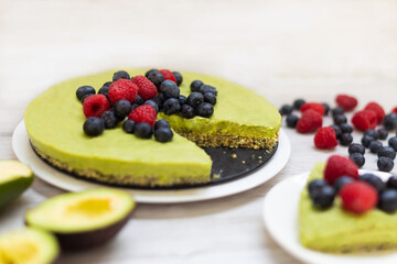 Tasty homemade avocado and lime Raw Cake with blueberries and raspberries, healthy vegan recipes