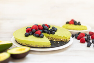 Tasty homemade avocado and lime Raw Cake with blueberries and raspberries, healthy vegan recipes