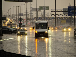 City highway in the evening with cars in the rain