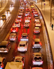Cars standing in the evening in the winter in a traffic jam on a city street