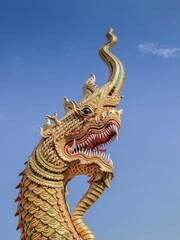 Fototapeta na wymiar Close-up Naga (Dragon) statue with blue sky background, Wat Nam Tok Mae Klang, Chiang Mai, northern of Thailand.