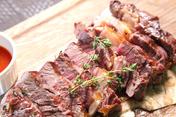 Delicious steak. Beef steak on wooden plate. Medium-roasted steak on a wooden board with sauce. 