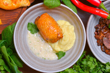 Roasted chicken with mashes potatoes served in a bowl with fresh organic greenery - dill, spinach, parsley.
