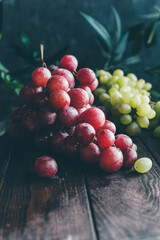 Red and green grapes on a wooden table