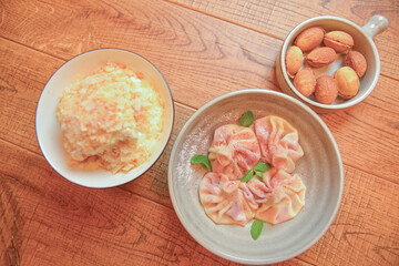 Sweet khinkali with cherry, Cookies called nuts with condensed milk and Cake Napoleon served in white plates.