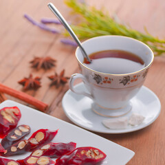 Tasty oriental sweets. Caucasian delicacy churchkhela - georgian nut treats. Served with a glass of tea and a tea pot.