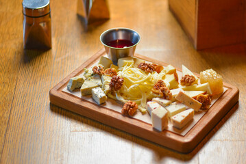 Different sort of farm made cheese served on a wooden board. Cheese platter with different kinds of cheese.