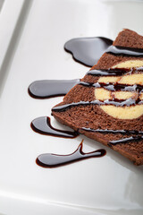 Chocolate bread stuffed with jam rolls topped with chocolate sauce