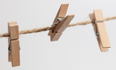 Clothespins hang on a rope on a white