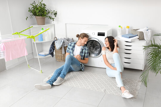 Happy Young Couple Doing Laundry At Home