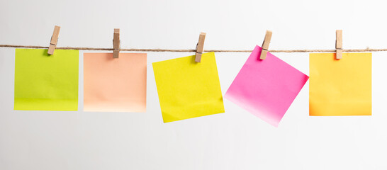 Colored papers hang on a rope on a white