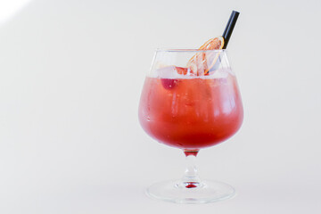 Cold summer alcohol cocktail with ice and orange in a small glass isolated on white background.
