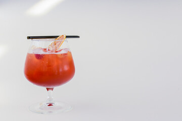Cold summer alcohol cocktail with ice and orange in a small glass isolated on white background.