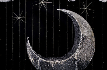 Photo booth zone studio with silver moon for sat and black wall with stars.