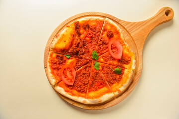 Traditional italian food. Delicious fresh pizza with bolognese sauce, tomatoes, pepper on wooden board, flat lay.