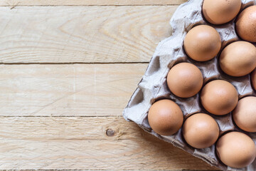 Top view eggs in paper panel on wooden table with copy space