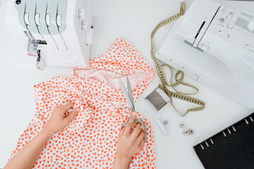 Top view of tailors workplace. Tailors hands preparing for sewing a shirt.