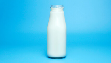 Fresh milk bottle isolated on blue background, Closeup Front view Food concept..