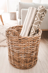 Wicker basket with rugs in room