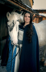 woman  in traditional dress with white horse