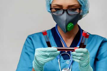 medical doctor nurse woman wearing protective mask and gloves - holding virus blood test tube