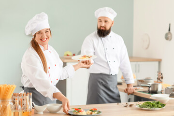 Male and female chefs cooking in kitchen