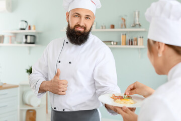 Male and female chefs cooking in kitchen