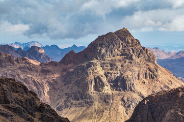 View of Moses mountain peak with a chapel on top illuminated by sunshine in the mountains of Sinai peninsula, Egypt 