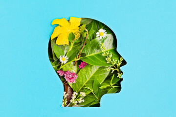 Papercut head with green leaves and flowers. Mental health, emotional wellness, contented emotions,...
