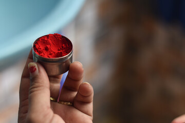 indian traditional sindoor (vermilion) box in a girl hand with shallow depth of field, Indian...