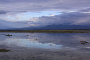 Obraz premium Blue clouds covering mountains and sky reflection