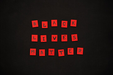 inscription black lives matter. protest signs. lettering. red letters on wooden squares on a black...