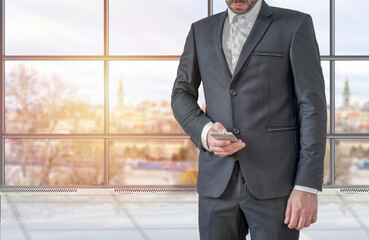 Fototapeta premium Businessman using mobile phone app texting inside office