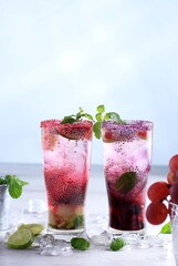 Grapes and Raspberry Mojitos in Two Tall Glass, White Background