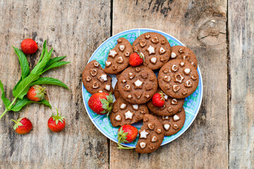    Fresh organic strawberries and cocoa cookies with  vanilla star decoration on wooden background. Summer dessert