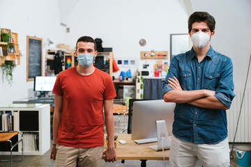 Obraz premium Portrait of millennials men with surgical mask at working in office at distance for protection and prevention from Coronavirus, Covid-19