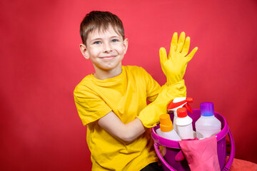 A boy in yellow gloves with cleaning products 