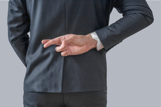 Businessman with his fingers crossed behind his back