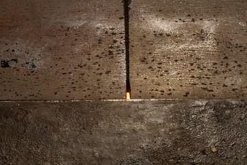 Detail of an old, rusty and often used iron cooking plates on a historic stove, with light of internal fire shining through a gap bewtween plates.
