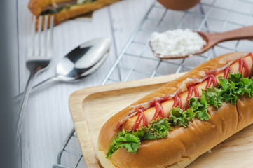 croque monsieur with slices of boiled ham, placed on a wooden plate with cooking tools.