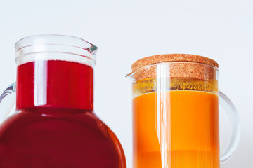 Two jugs of berry juice. Sea buckthorn juice and juice from different berries.