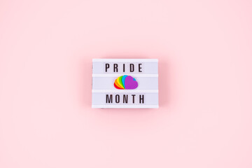 Pride month, LGBT flag symbol concept with Six rainbow color hearts on pink background with text pride month