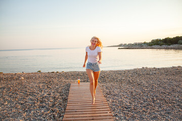 Hot blond woman running on the uninhabited beach. the lifestyle of people are the happiness...