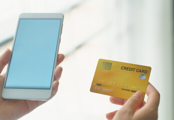 Woman holding mock up credit card  while using smartphone for shopping online by credit card.Shopping and payment online.