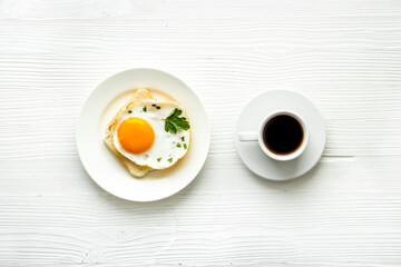 Fried eggs sandwich on plate - white wooden desk from above